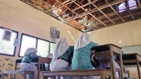 Sejumlah siswa kelas V SDN Inpres Kalemba Desa Kawuwu Kecamatan Langgudu Kabupaten Bima berupaya tetap belajar di bawah ancaman atap kelas yang nyaris ambruk, Rabu (26/8/2026). Foto US/ Berita11.com.